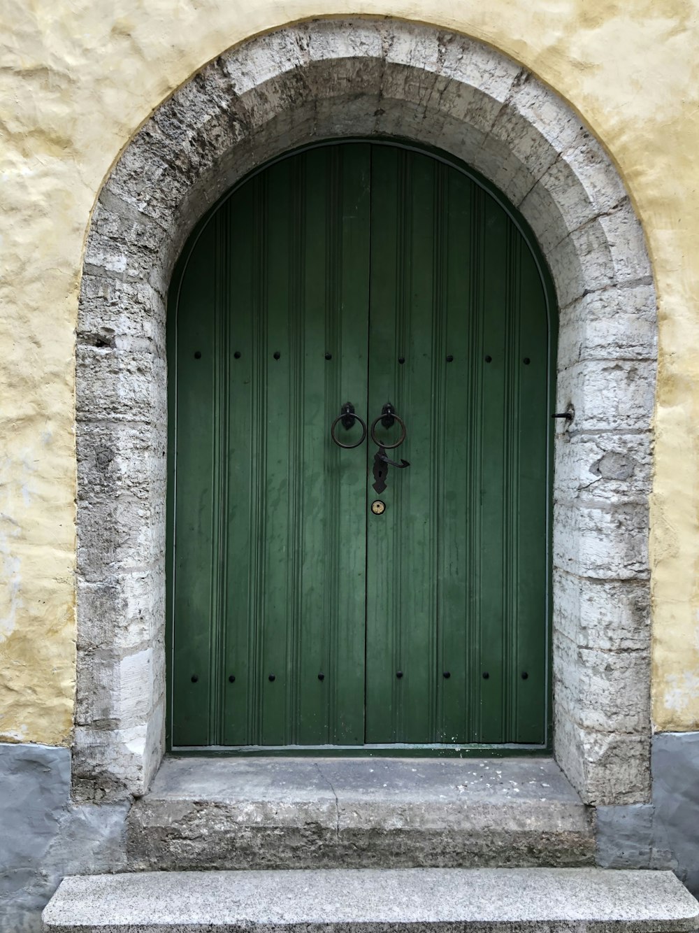 검은색 노커가 있는 녹색 문