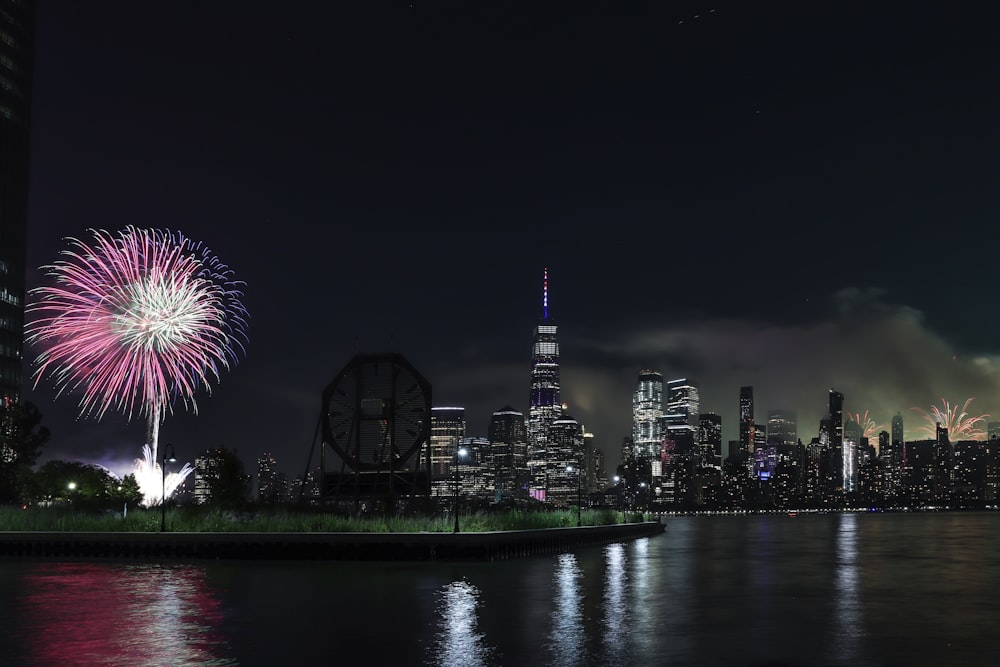 fireworks are lit up in the night sky over a city