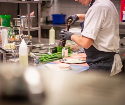 man putting herb on food cook teams background