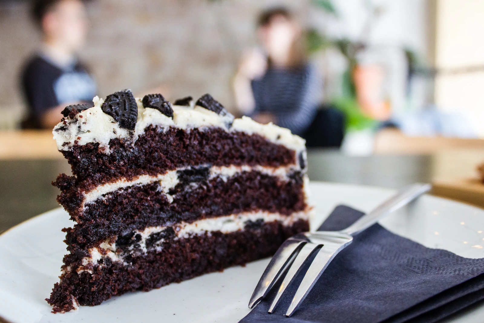 Layered chocolate celebration cake slice on a plate
