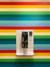 gray and white phone on multicolored striped wall