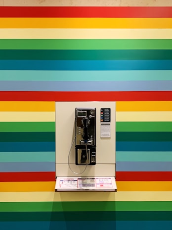 gray and white phone on multicolored striped wall