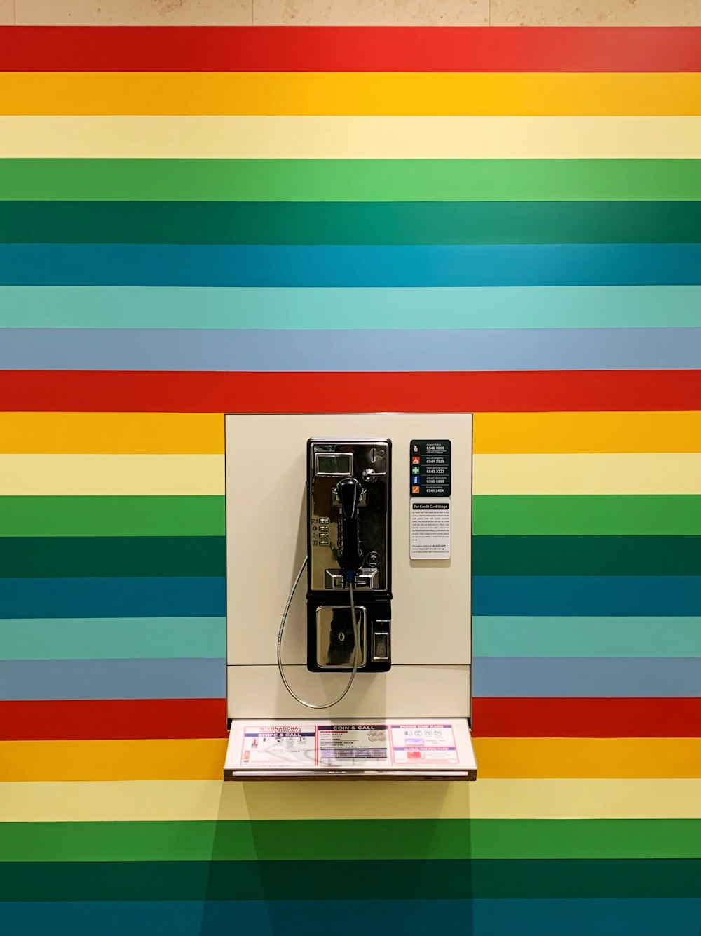 gray and white phone on multicolored striped wall
