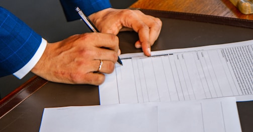 person writing on white form paper