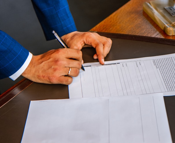 person writing on white form paper