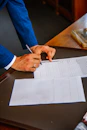 person writing on white form paper