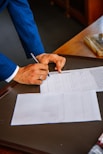 person writing on white form paper
