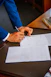 person writing on white form paper