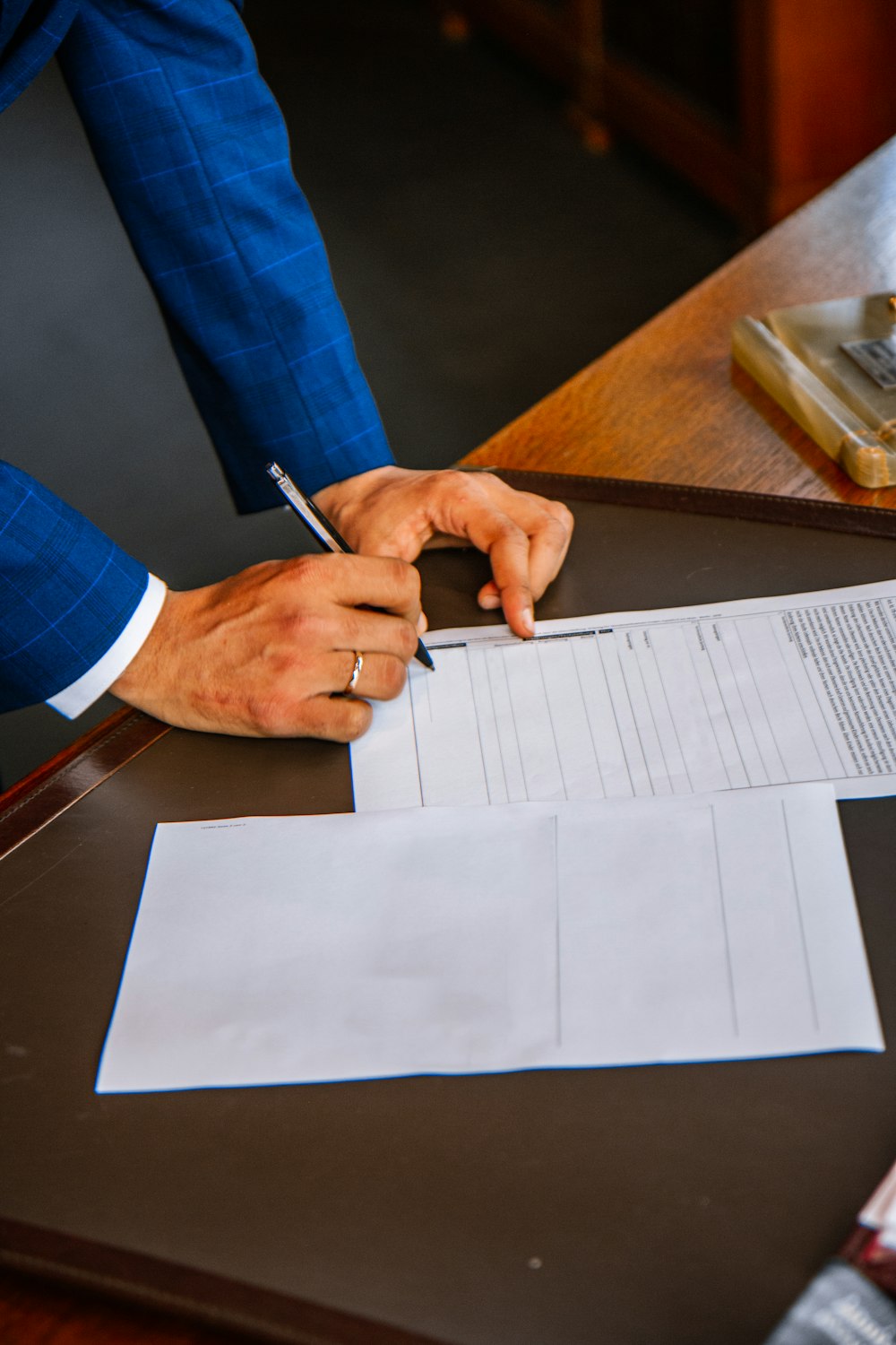 personne écrivant sur du papier blanc