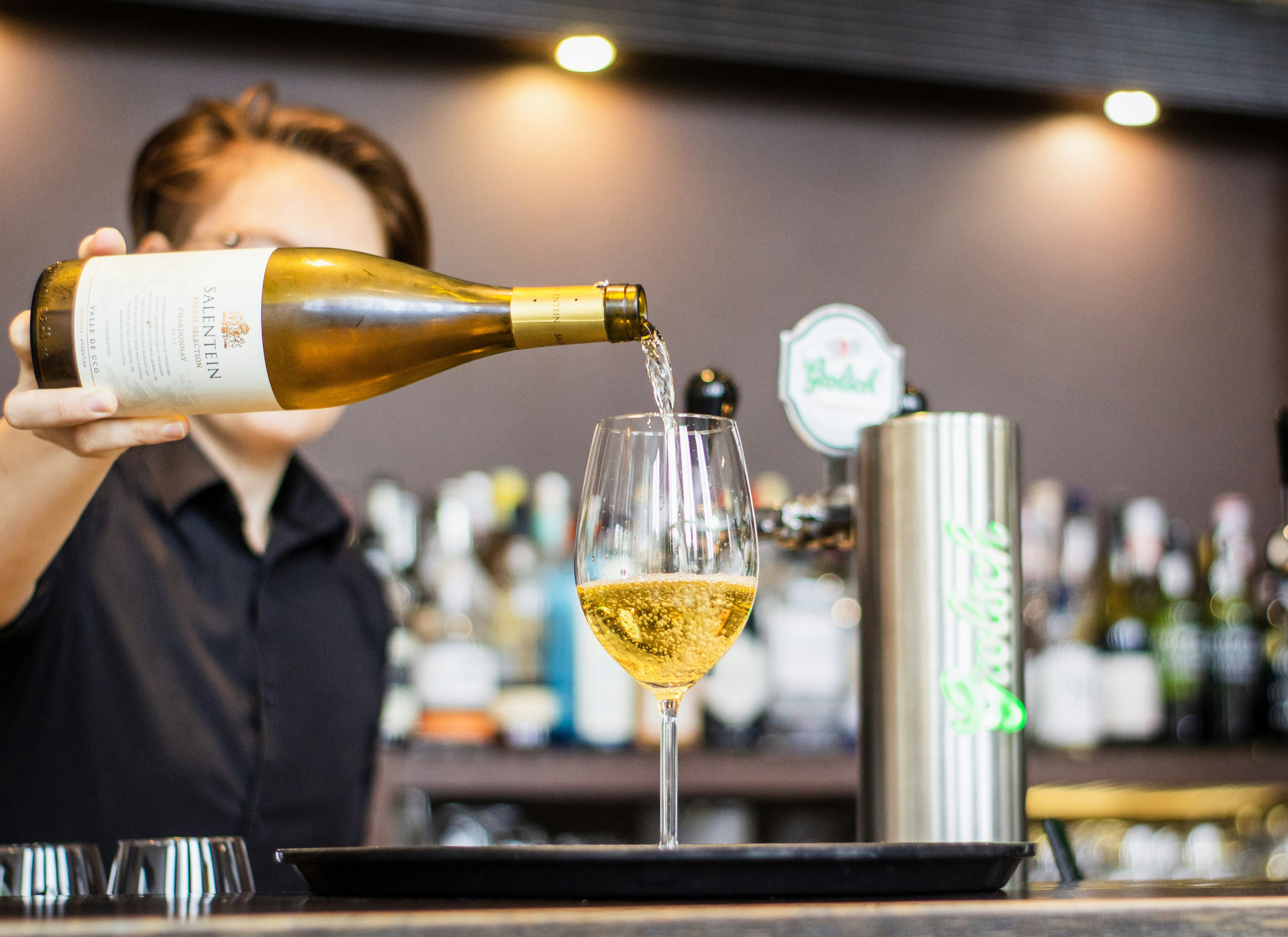 man pouring wine in wine glass