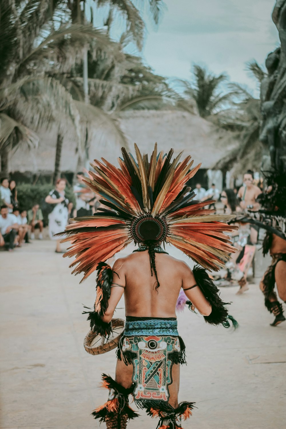 people in tribal mask standing at the shore