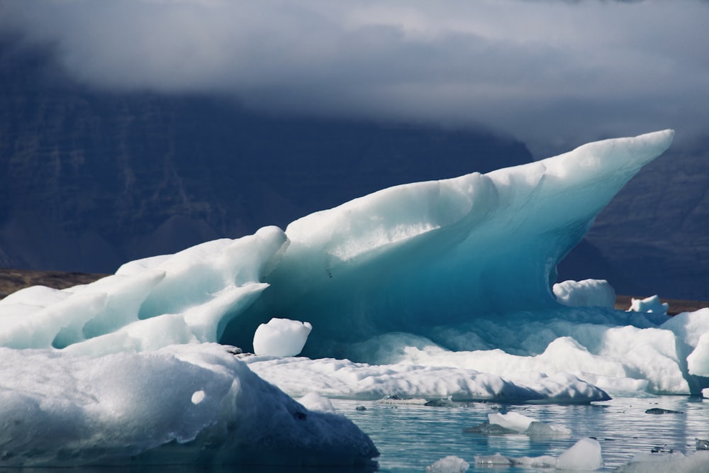 um grande iceberg flutuando em cima de um corpo de água