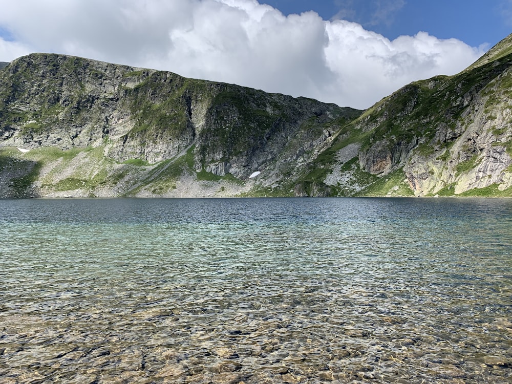 photography of mountain range beside body of water during daytime