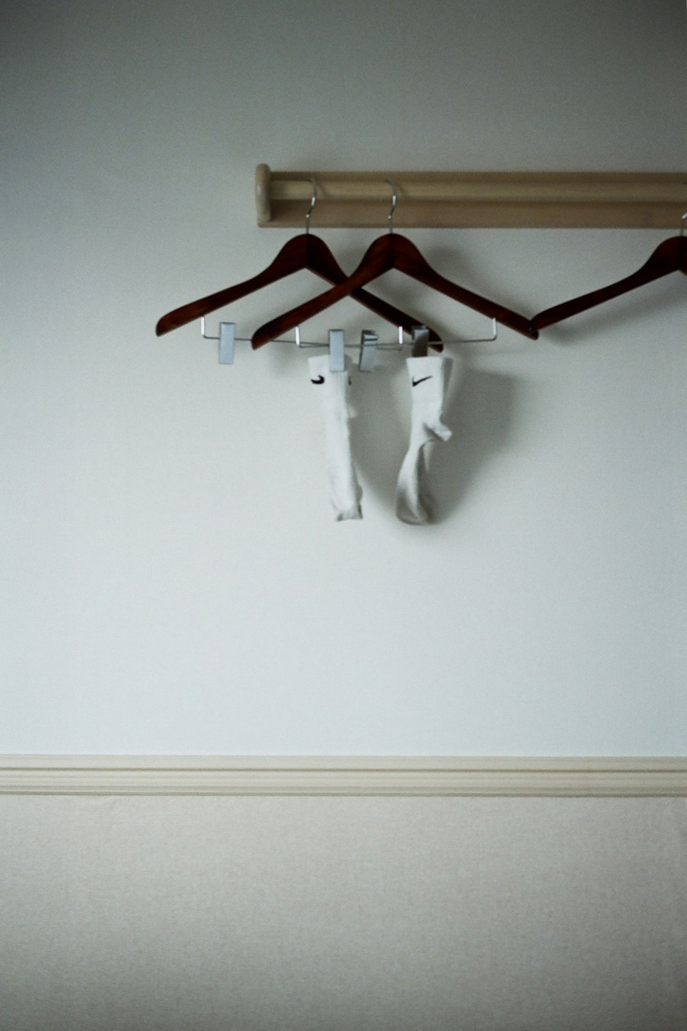 white Nike socks on clothes hanger near wall