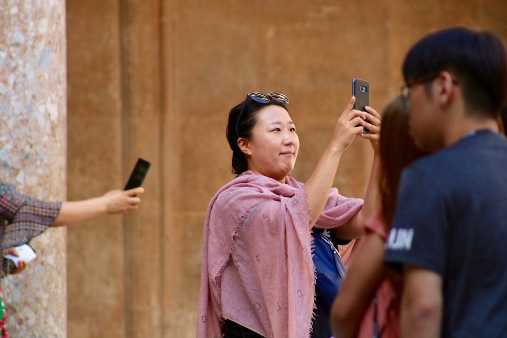 woman holding smartphone beside people