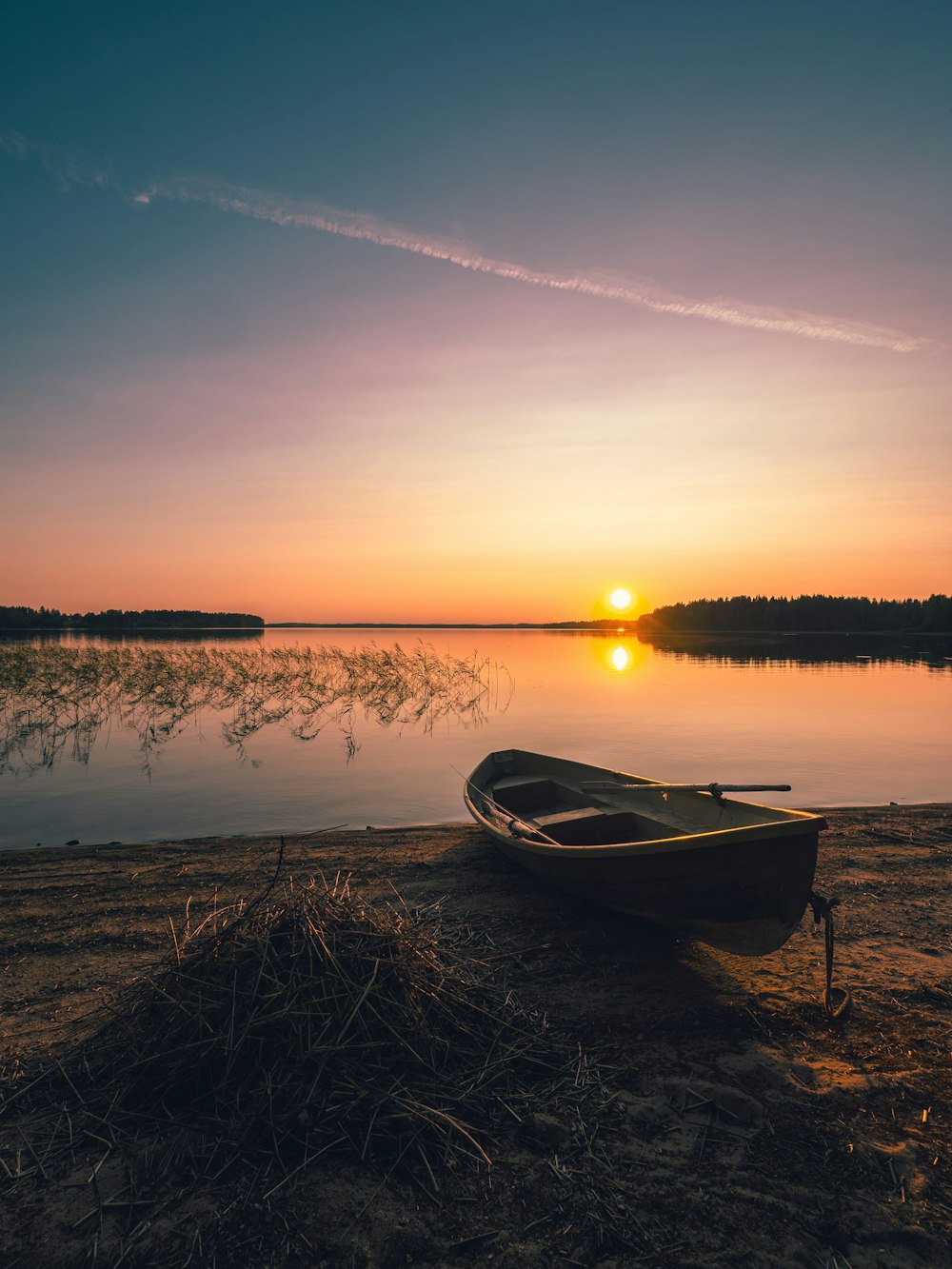 bateau sur le rivage au lever du soleil