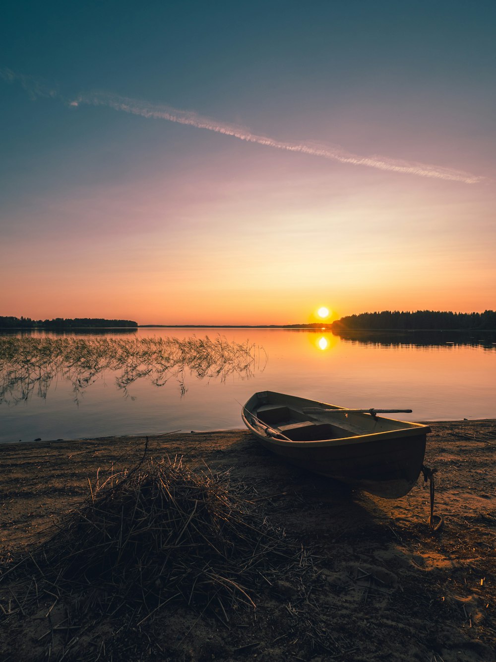 boat on shoreline at sunrise