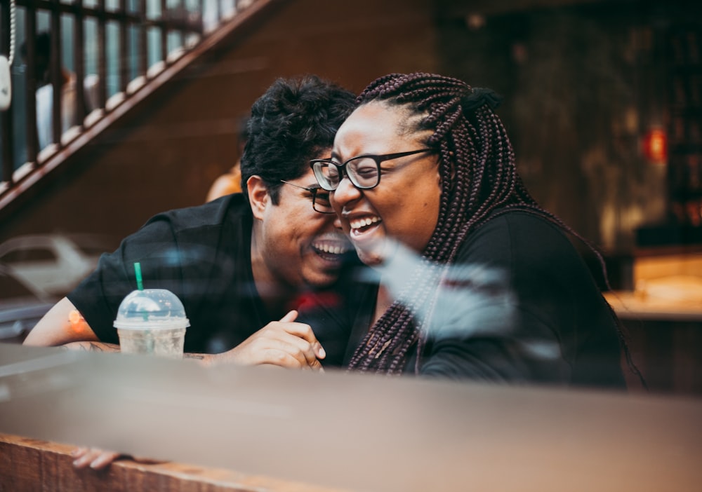 man and woman sitting and laughing