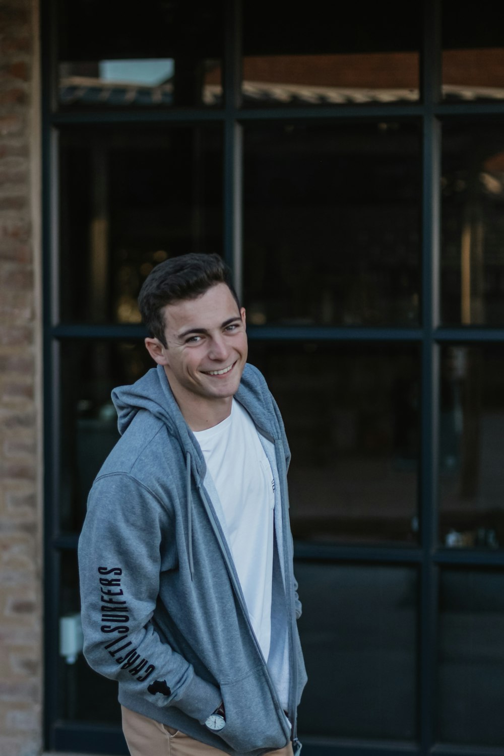 smiling man standing beside glass wall