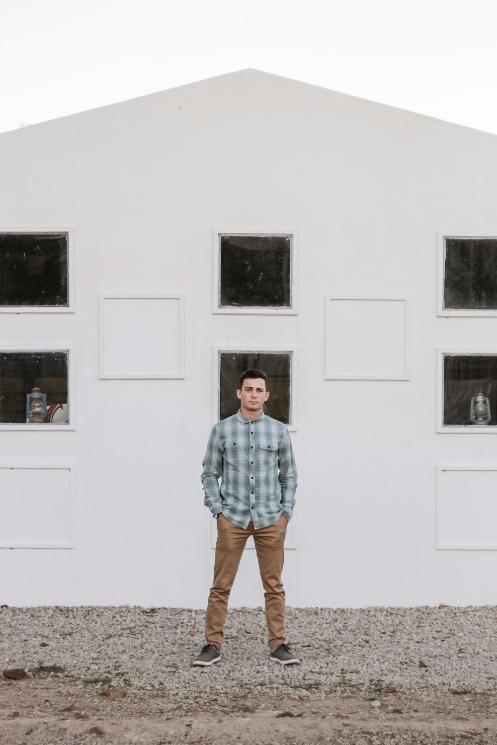 man standing beside white house