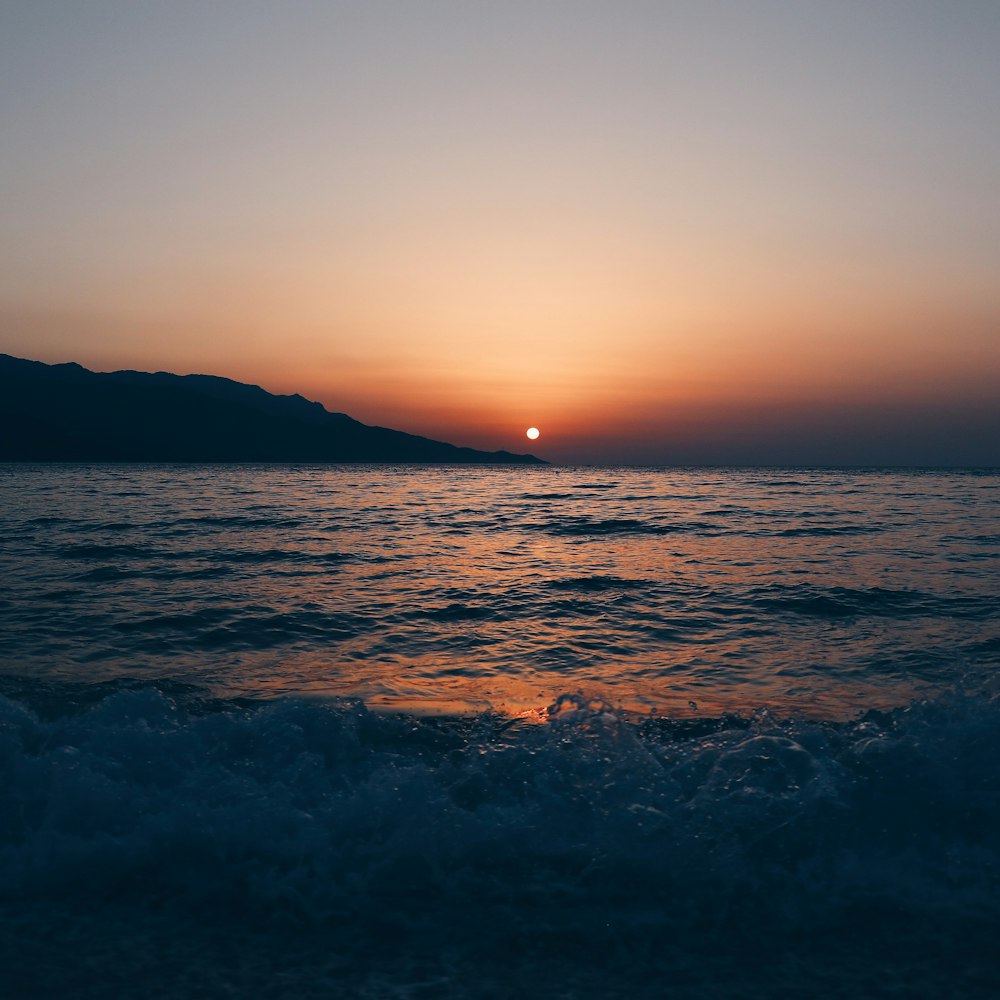 sun setting at the horizon over the sea