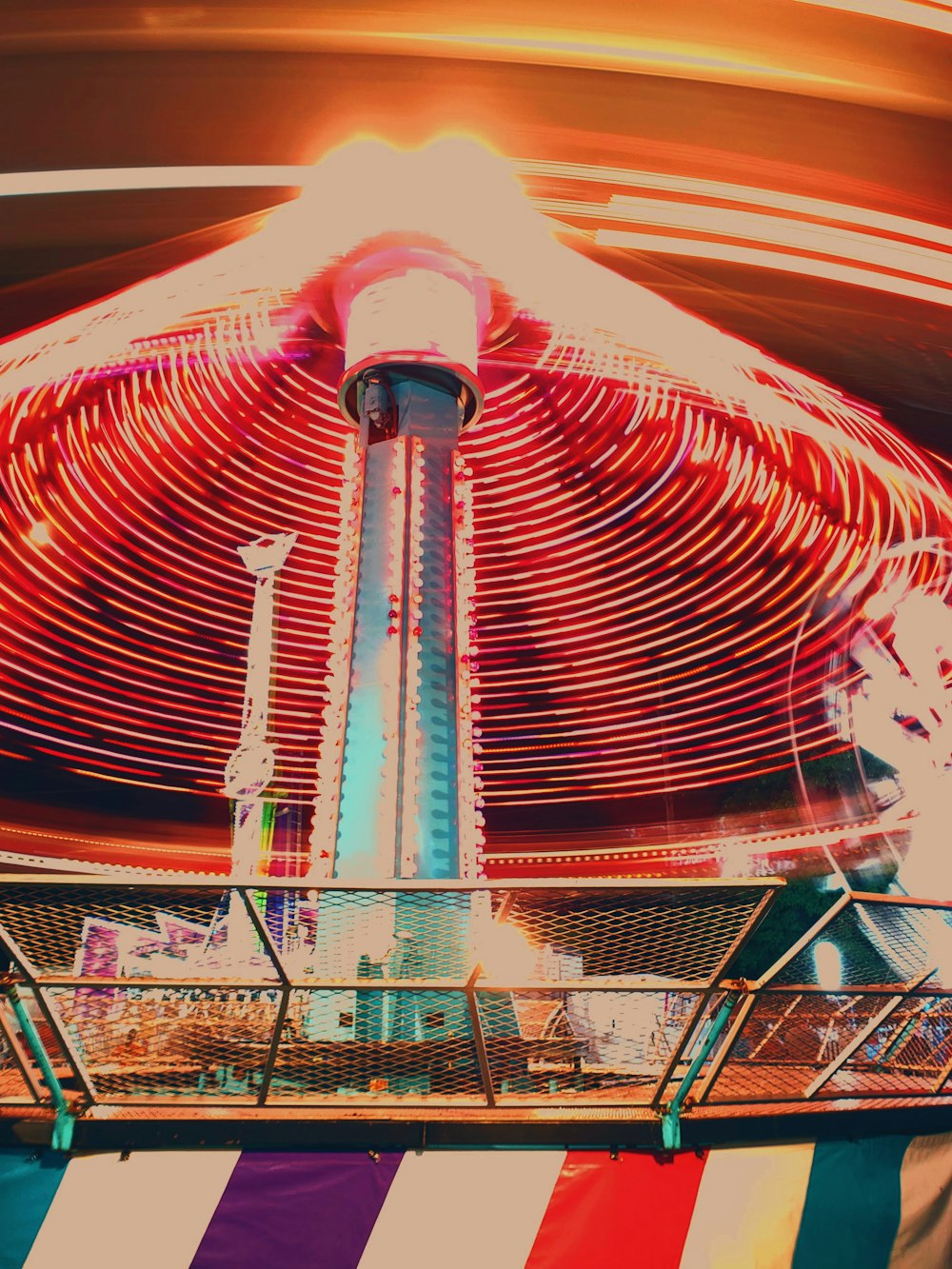 a carnival ride with a ferris wheel in the background