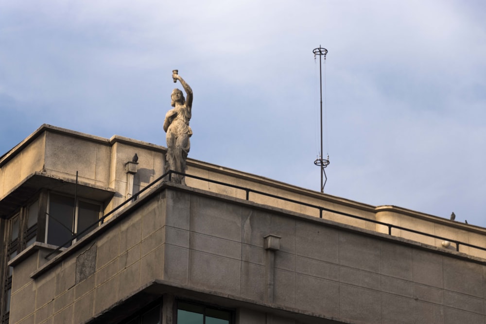 gray concrete building with female statue