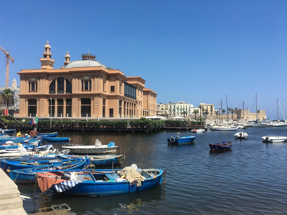 blue and white boats on sea viewing building