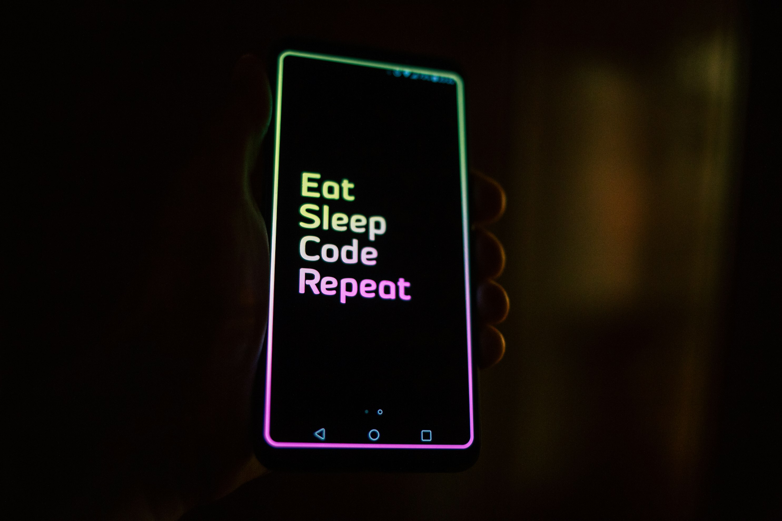 black Android smartphone showing the words Eat Sleep Code Repeat