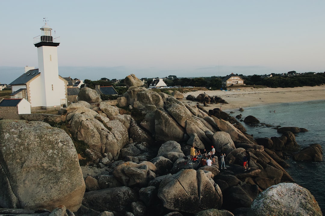 people standing on coastal boulder during daytime