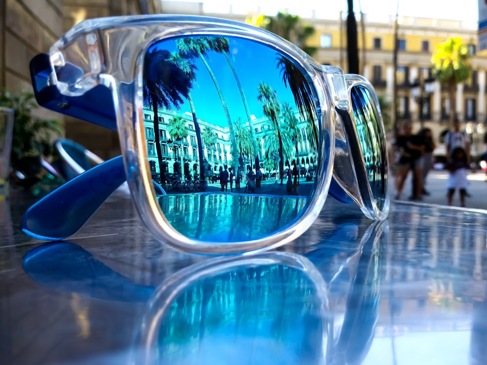 gafas de sol con montura gris y azul sobre mesa gris