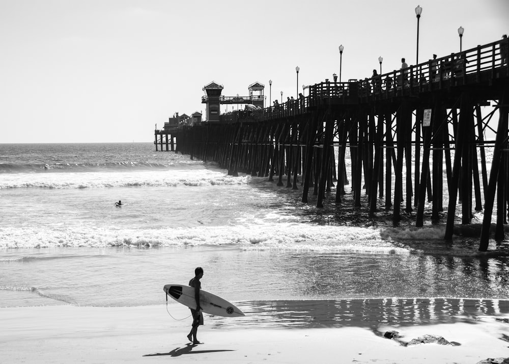 standing person holding surfboard