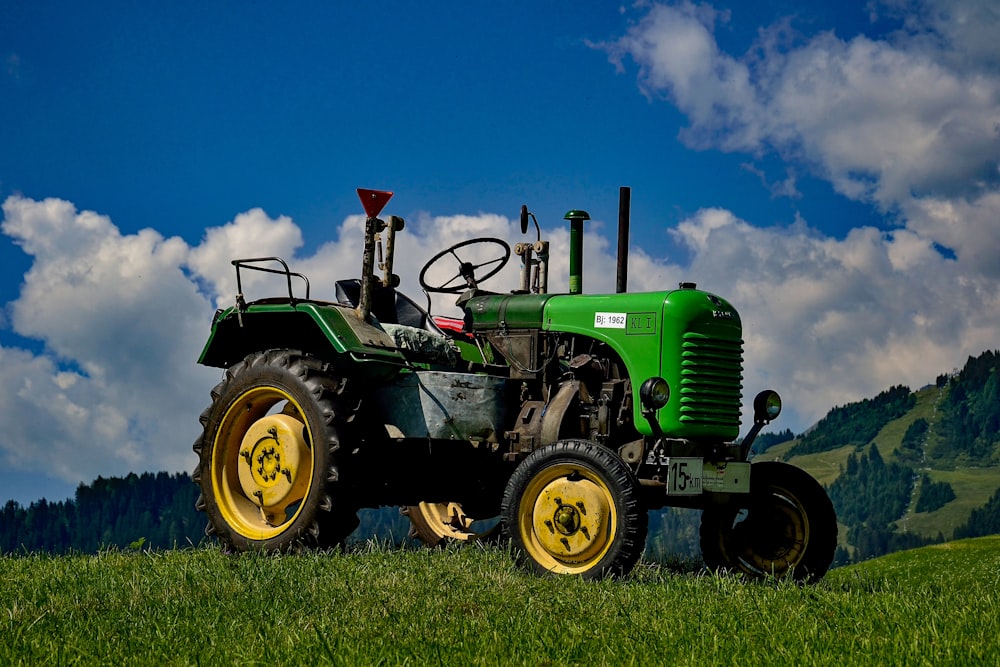Grüner und schwarzer Traktor auf grüner Wiese unter blau-weißem Himmel