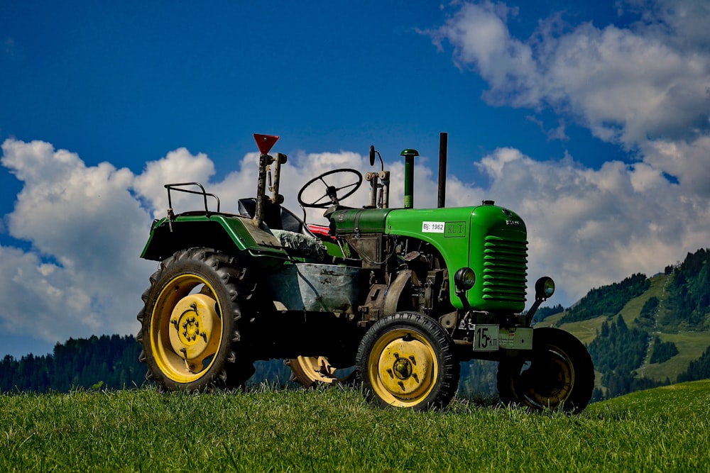 tracteur vert et noir dans un champ vert sous un ciel bleu et blanc