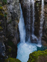 A powerful waterfall plunging into a crystal-clear pool below.