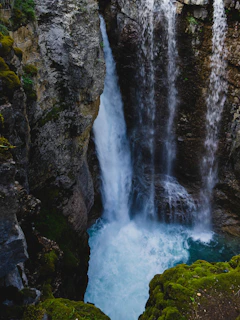 A powerful waterfall plunging into a crystal-clear pool below.