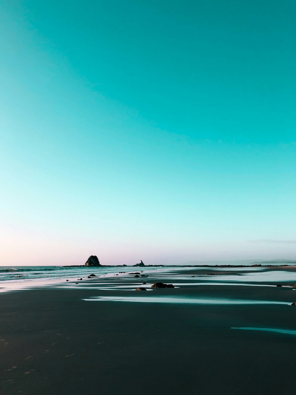 Photographie de paysage de bord de mer sous un ciel bleu calme pendant la journée