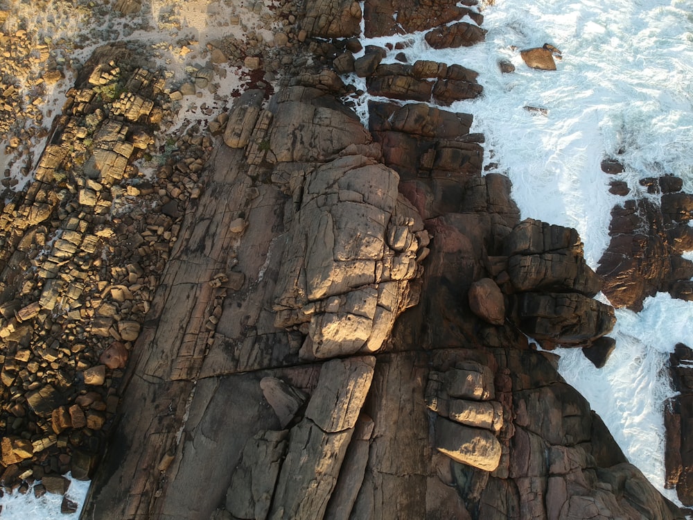 aerial photography of waves crashing on coastal rocks