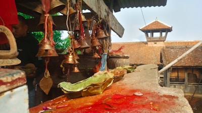 Handcrafted pooja bells hanging against a rustic backdrop.