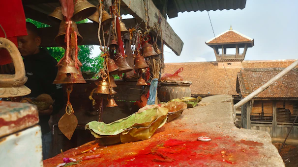 A set of polished brass pooja bells arranged neatly on a wooden altar.