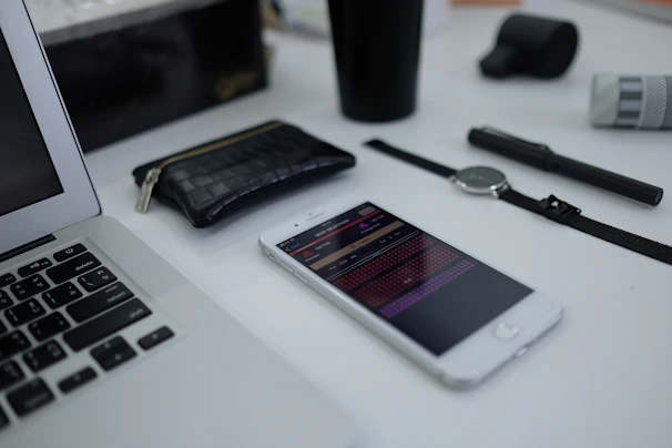 An assortment of everyday items and tech accessories artfully arranged on a smooth surface with natural shadows.