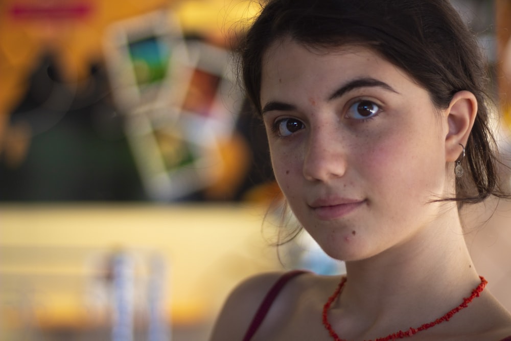 selective focus photo of woman wearing red beaded necklace