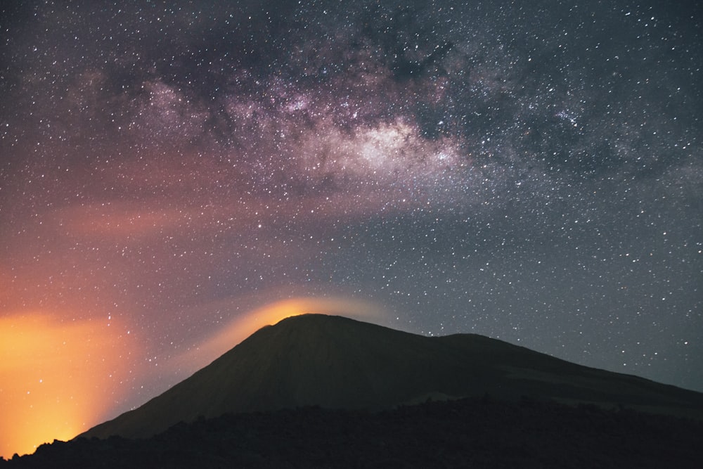 silhouette of mountain under milky way