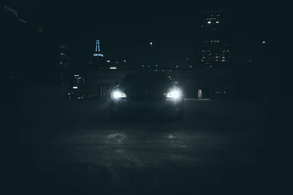 Car headlights on a dark street at night during mobile surveillance