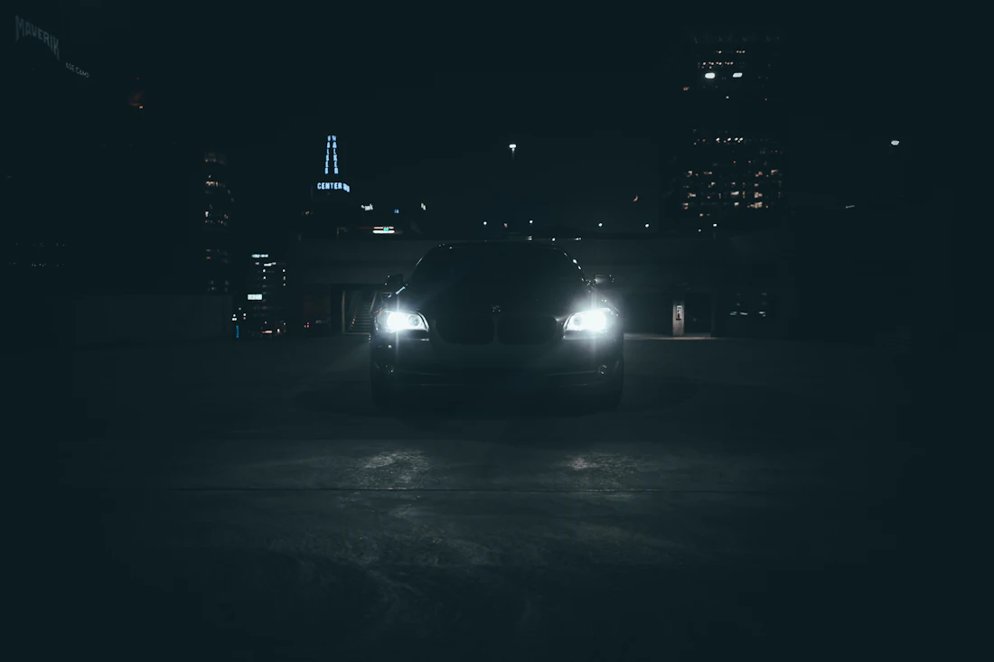 Car headlights on a dark street at night during mobile surveillance