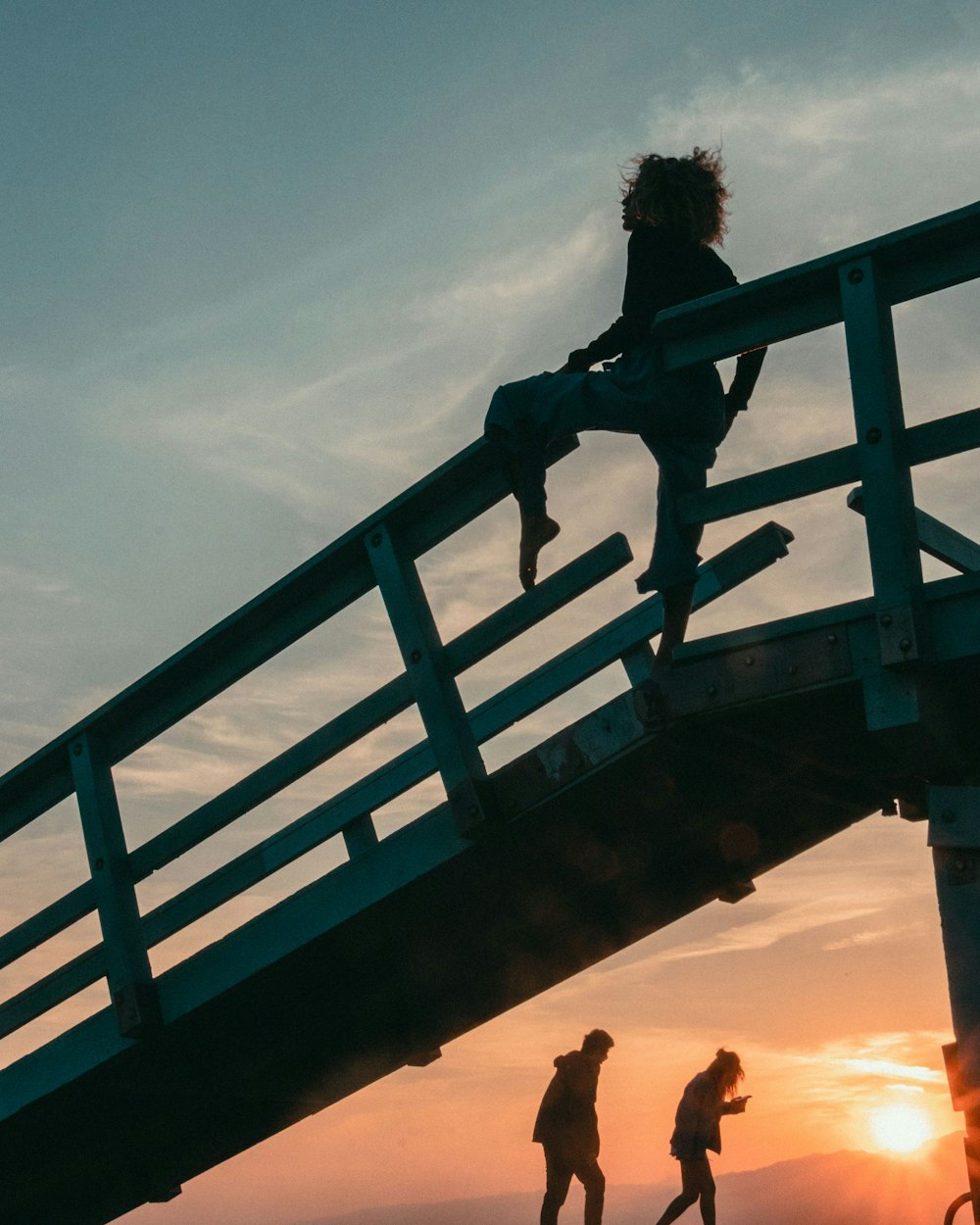 woman standing on wooden dock near man and woman walking