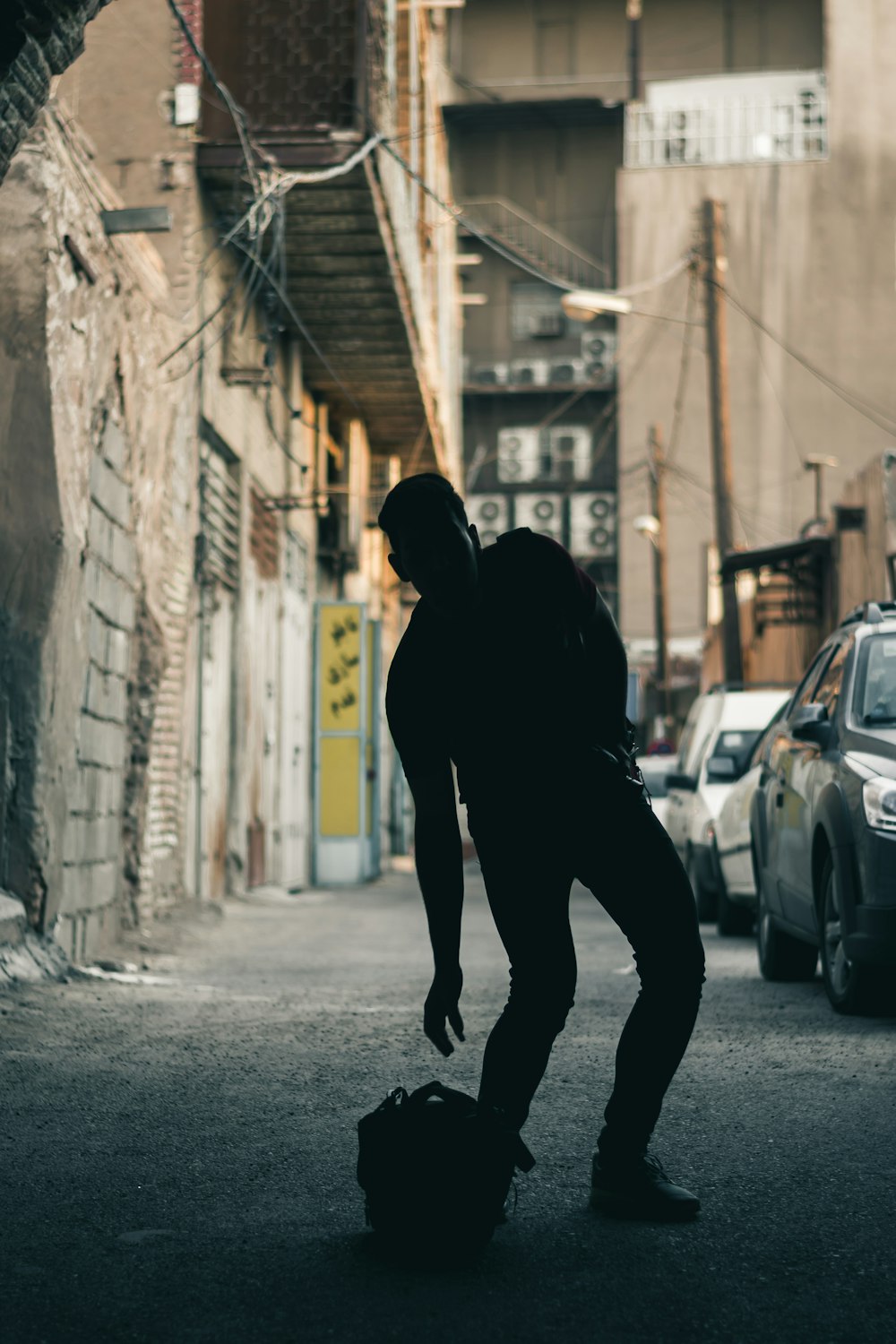 man standing beside concrete building during daytime