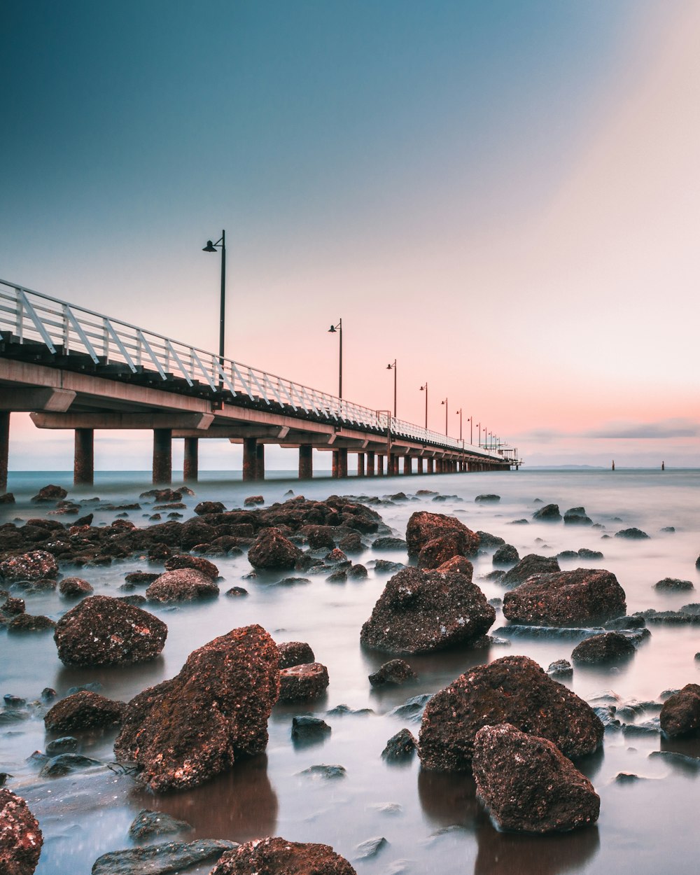 blue body of water and concrete bridge during daytime