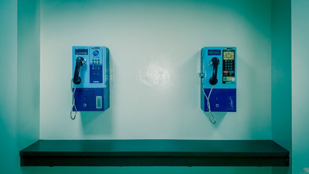 two white and blue telephones close-up photography