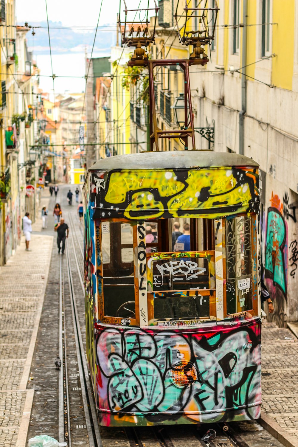 a trolley car covered in graffiti on a city street